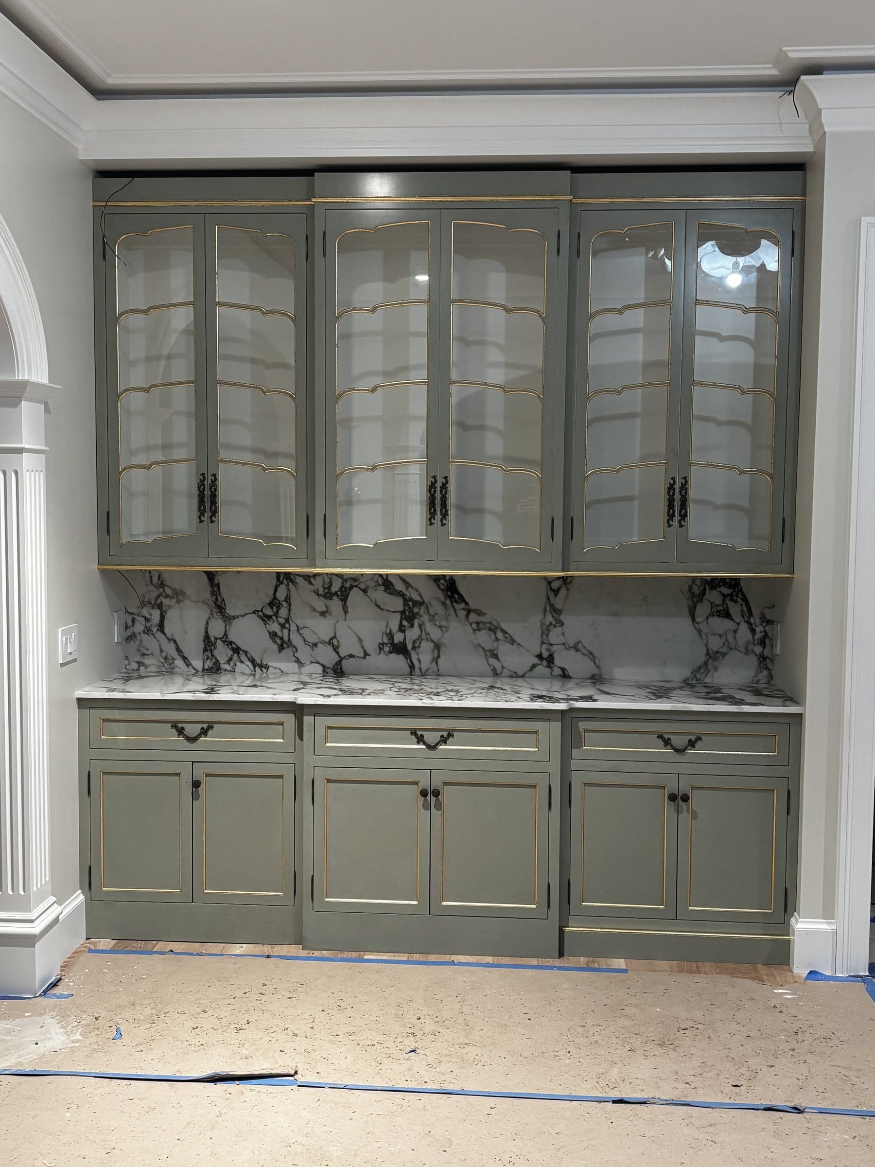 Photo of custom green cabinetry with marble backsplash on site