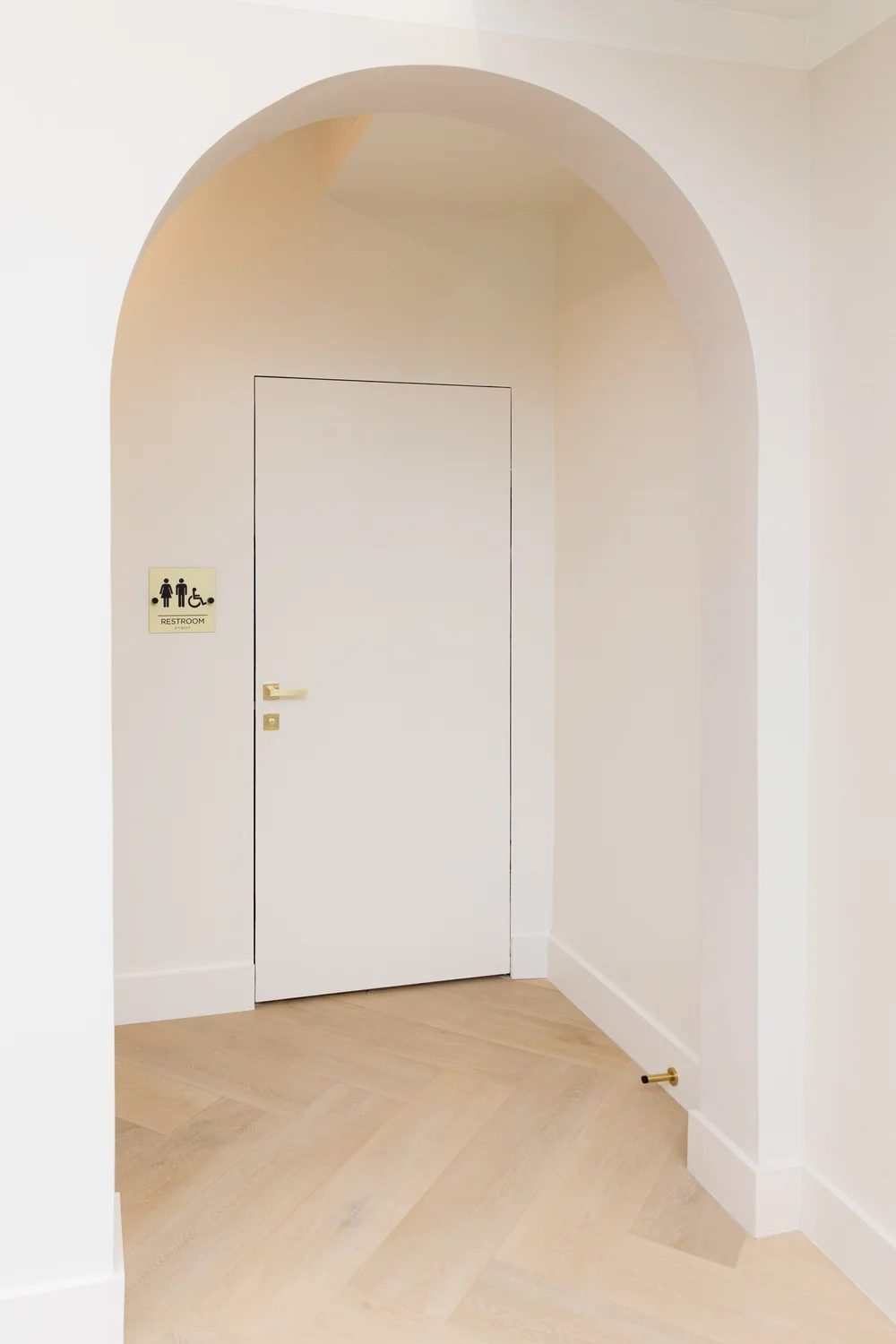 Arched hallway leading to the bathroom
